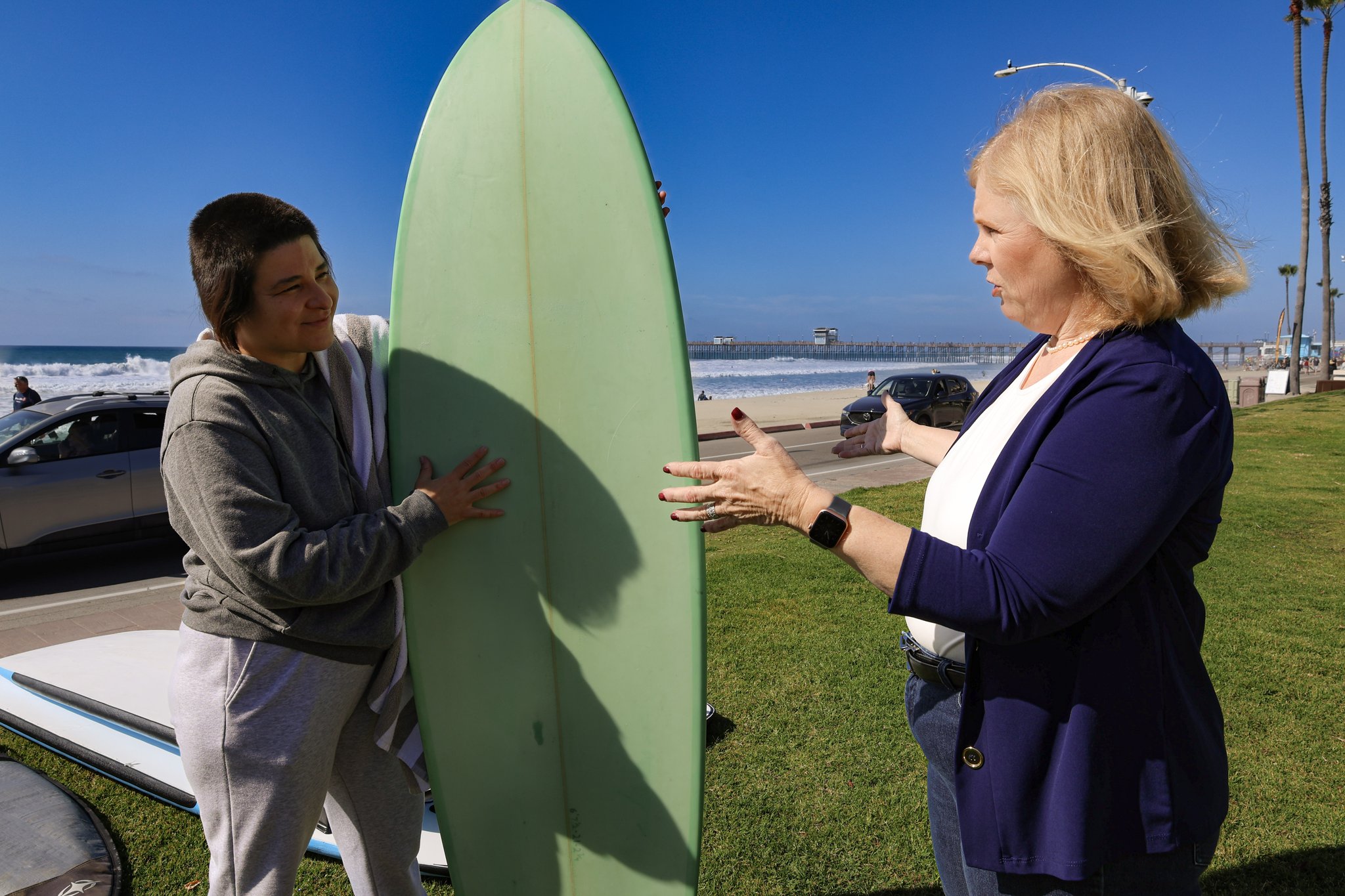 Laura talking with a surfer near the beach